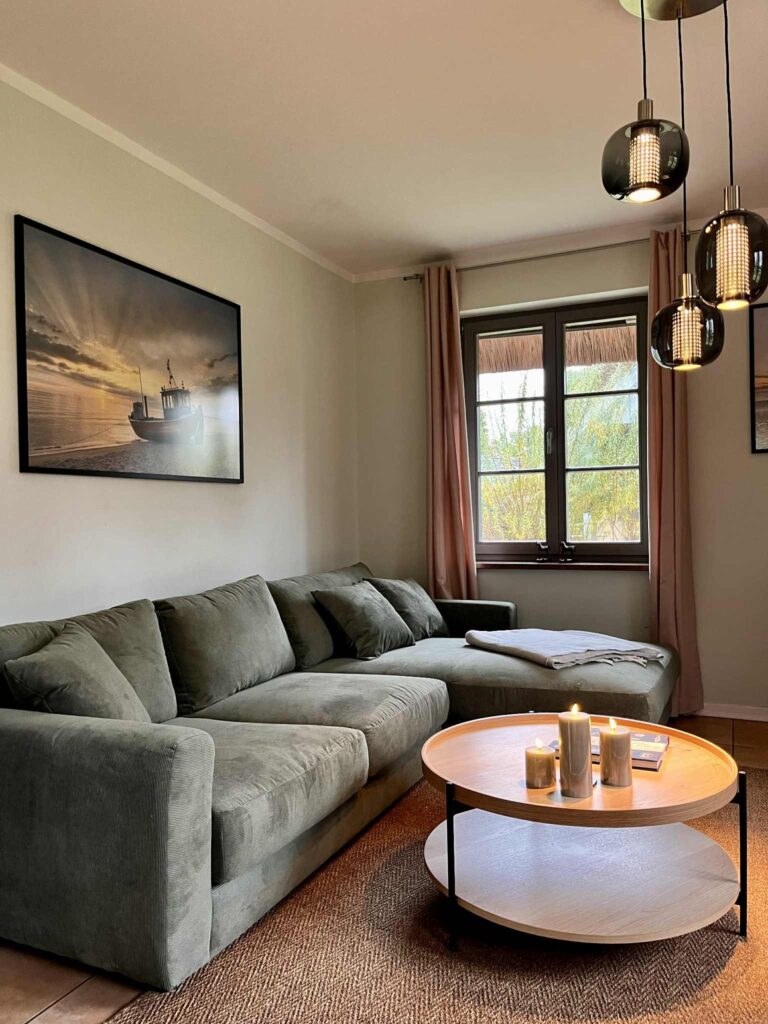 Hier ist unser Wohnzimmer im Ferienhaus Feldlerche auf Usedom am Stettiner Haff an der Ostsee abgebildet. Es hate eine grosse Couch und einen Sessel sowie eine TV-Ecke.